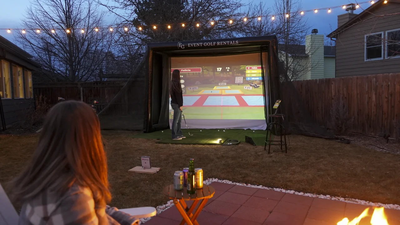 Outdoor golf simulator private party at dusk with fire pit in Northern Colorado